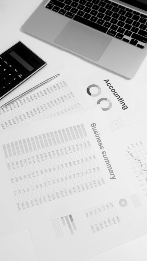 Overhead view of a workspace with financial documents, laptop, and calculator, ideal for business analysis concepts.